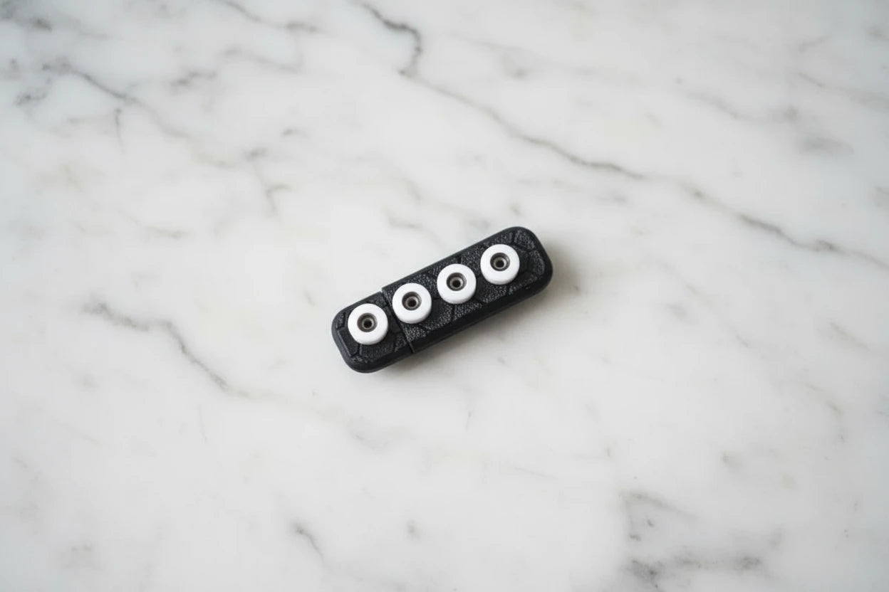 White ABS fingerboard wheels on black casing for transportation.