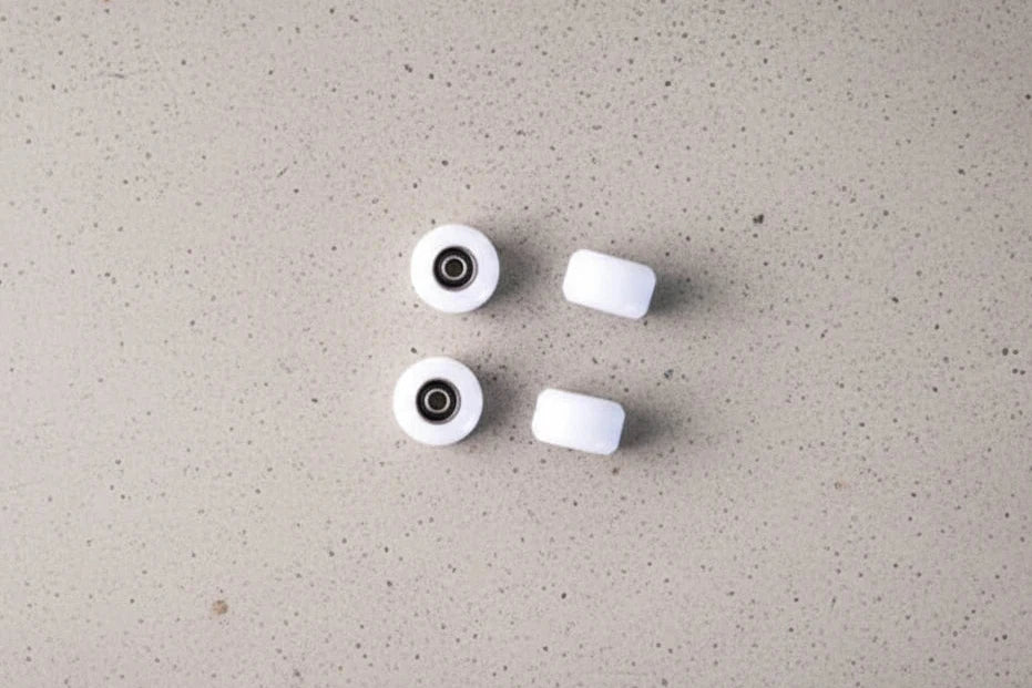 White ABS fingerboard wheels with bearings on concrete